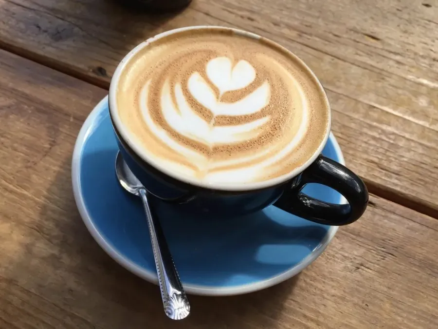Café con leche con arte latte en taza de cerámica